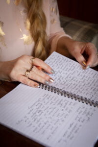 Image is of Leslie's hands writing in a notebook